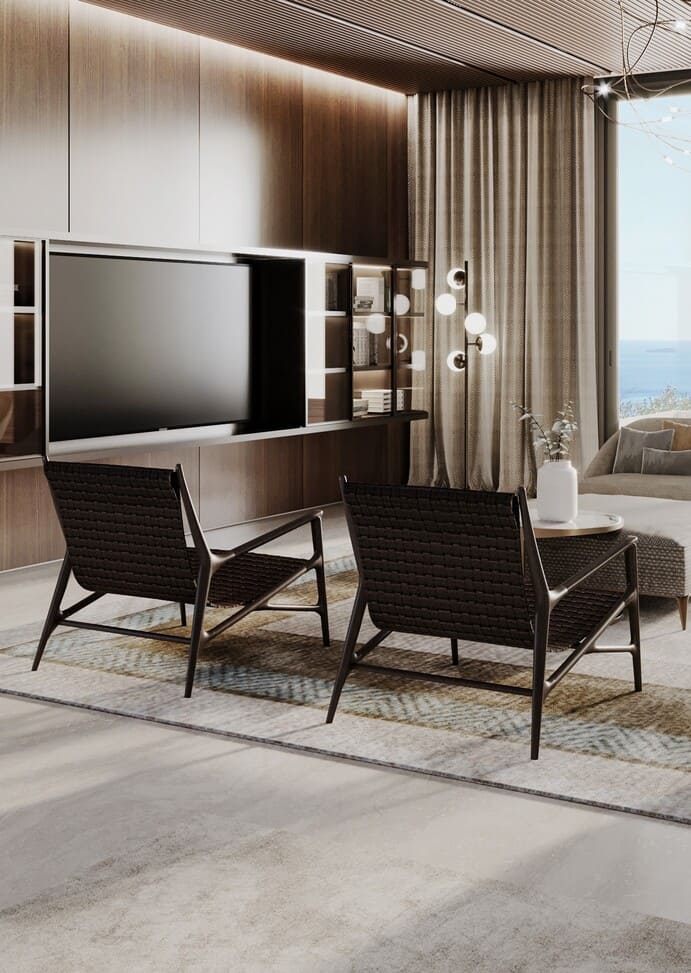 A close-up view of a living space with textured chairs, a TV set against a wooden backdrop, and a glimpse of the sea through curtains.